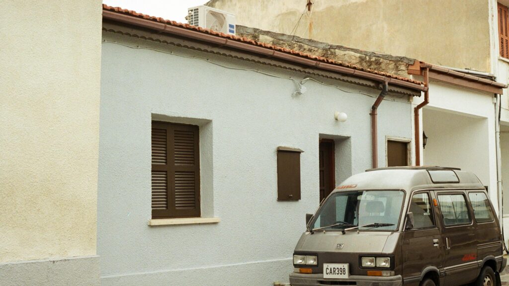 Vintage Brown JDM Van Parked by Blue Mediterranean House Desktop Wallpaper