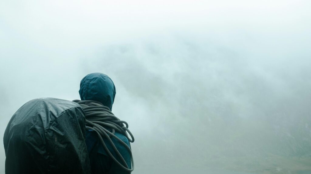 Solo Hiker Standing in Misty Mountain Fog 4K Wallpaper