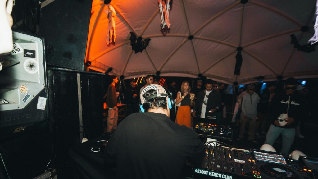DJ Performing at Late Night Beach Club Party 4K Desktop Wallpaper
