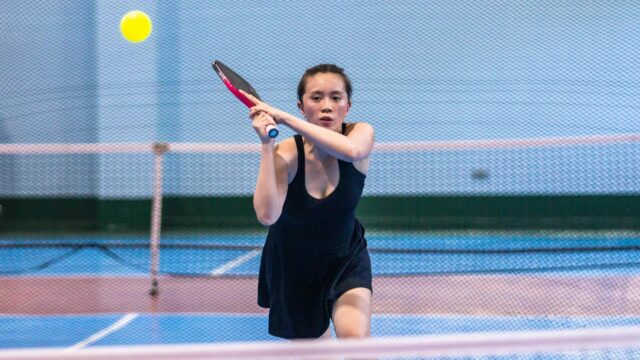Focused Female Pickleball Player Swinging Racket 4K Wallpaper