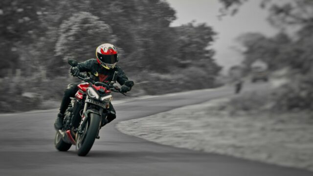 Triumph Street Triple Red Motorcycle Racing Through A Scenic Bend 4K Wallpaper