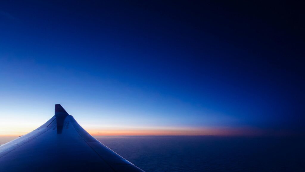 Stunning Airplane Wing at Sunrise Above Clouds Desktop Wallpaper