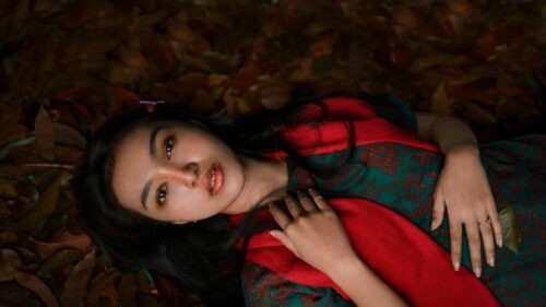 Beautiful Woman Lying on Autumn Leaves Portrait 4K Wallpaper