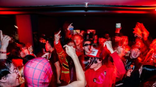 Energetic Nightclub Party Crowd Celebrating in Red Lighting 4K Wallpaper