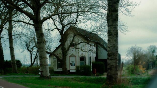 Rustic Countryside Cottage Under Bare Winter Trees Desktop Wallpaper
