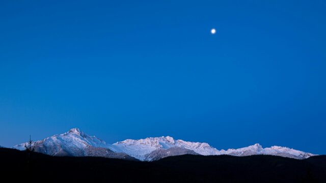 Moon Over Snow Covered Mountain Peaks at Twilight Desktop Wallpaper