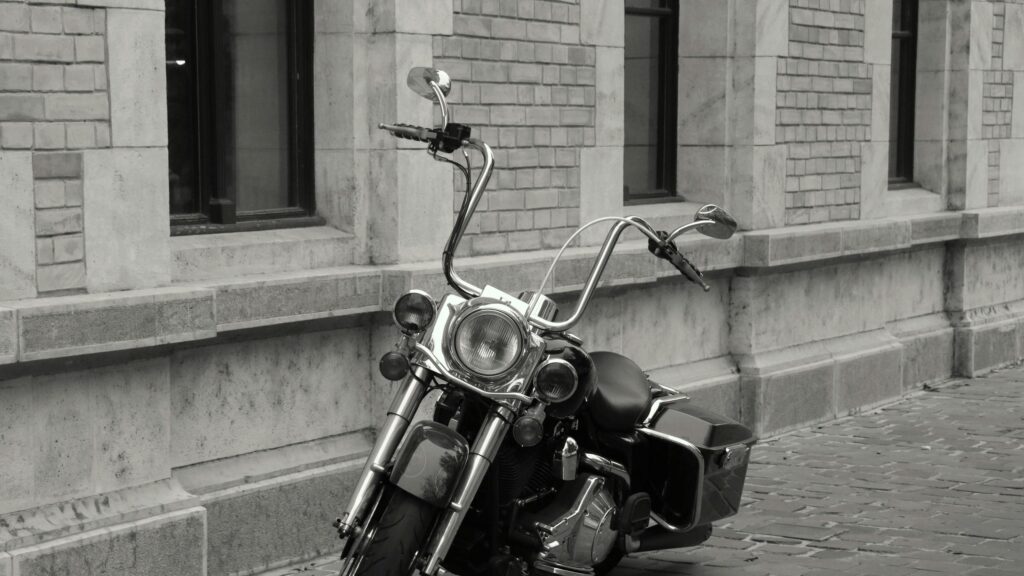 Black and White Harley Davidson Motorcycle parked against classic stone wall 4K Wallpaper