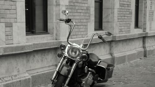 Black and White Harley Davidson Motorcycle parked against classic stone wall 4K Wallpaper