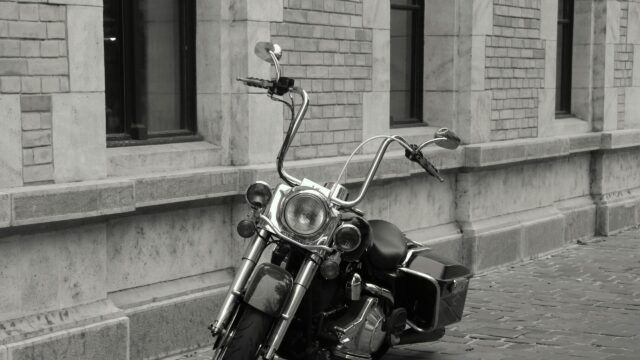 Black and White Harley Davidson Motorcycle parked against classic stone wall 4K Wallpaper