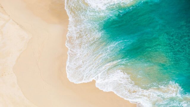 Stunning Aerial View of Tropical Sandy Beach and Turquoise Ocean 4K Wallpaper
