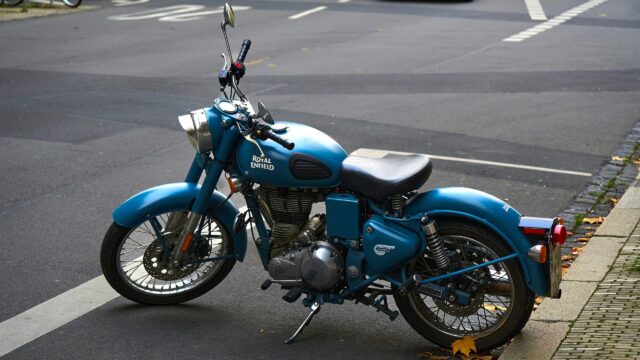 Classic Blue Royal Enfield Motorcycle parked on City Street 4K Wallpaper