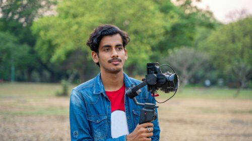 Young Videographer Holding Camera Gimbal in Nature 4K Wallpaper