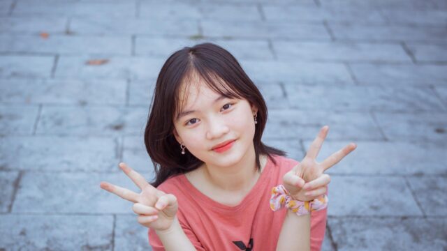 Cute Smiling Asian Girl Making Peace Signs 4K Desktop Wallpaper