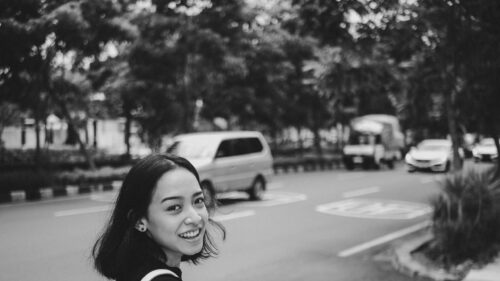 Young Woman Smiling on City Street Black and White Desktop Wallpaper