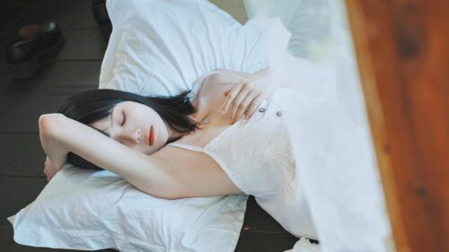 Serene Young Woman Sleeping in White Dress Desktop Wallpaper