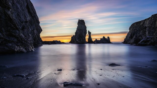 Stunning Seascape with Jagged Rock Formations at Sunset Desktop Wallpaper