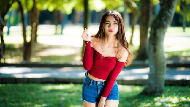Beautiful Asian Girl Making Finger Heart Gesture in Park Desktop Wallpaper