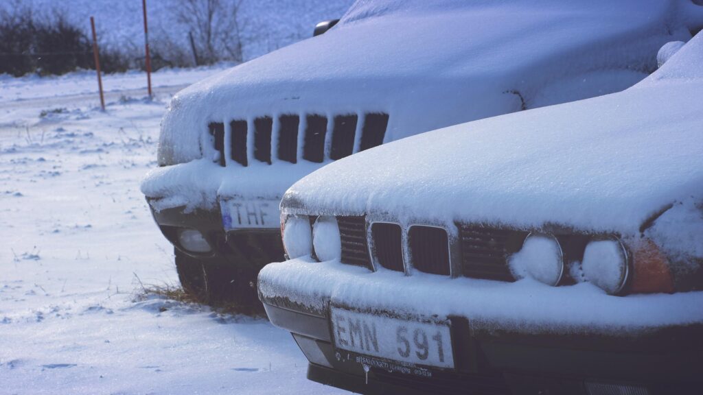 Frozen Luxury Cars Parked in Deep Winter Snow Desktop Wallpaper