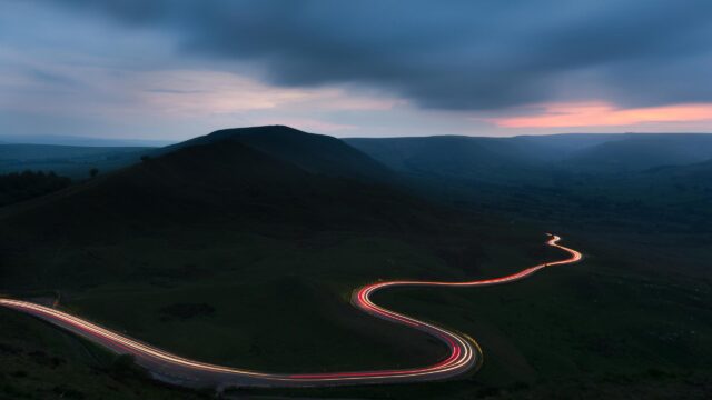 Winding Mountain Road at Night with Light Trails 4K Wallpaper