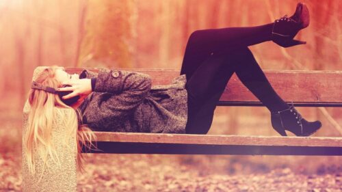 Blonde Woman Relaxing on Bench with Headphones Autumn Aesthetic Desktop Wallpaper