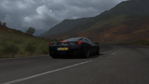 Black Ferrari 458 Italia Driving on Scenic Mountain Road 4K Wallpaper