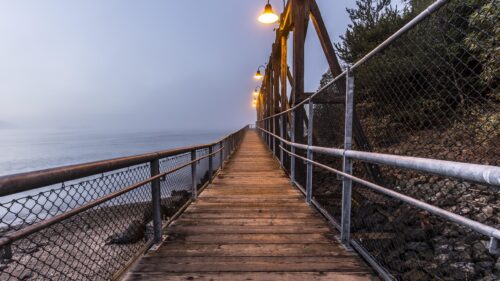 Misty Coastal Pier Walkway at Twilight Desktop Wallpaper