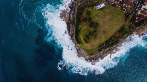 Aerial View of Coastal Cliff Waves Crashing Against Shoreline Desktop Wallpaper