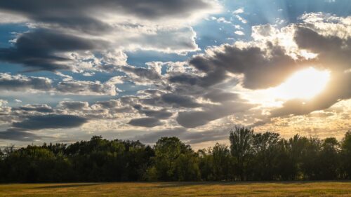 Dramatic Sunlit Clouds Over Green Forest Landscape PC Wallpaper