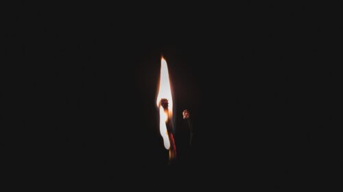 Minimalist Burning Matchstick Against Black Background 4K Wallpaper