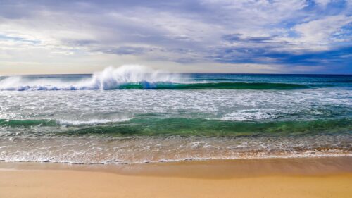 Stunning Ocean Wave Crashing on Sandy Beach 4K Desktop Wallpaper