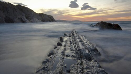 Dramatic Coastal Sunset with Jagged Rock Formations Desktop Wallpaper