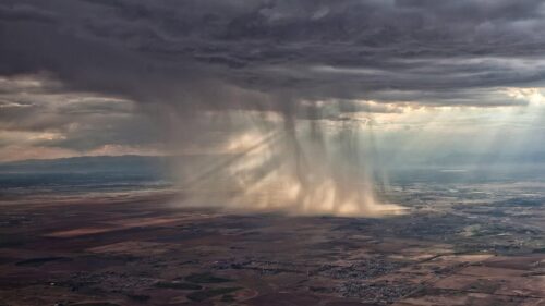 Dramatic Aerial View of Rain Shower and Sunbeams Over Landscape PC Wallpaper