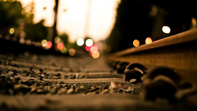Low Angle View of Industrial Train Tracks at Twilight 4K Desktop Wallpaper