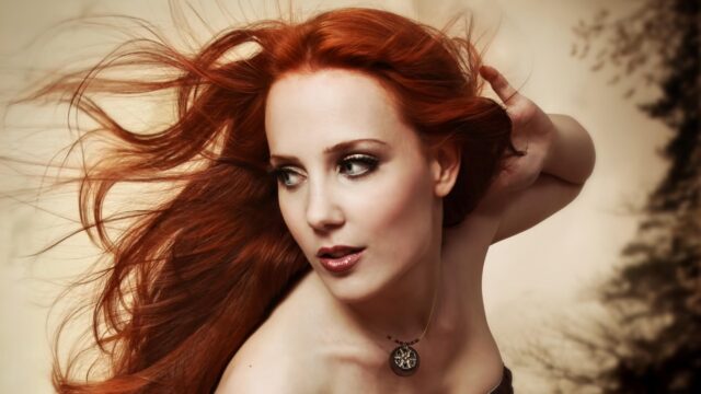 Stunning Portrait of a Woman with Flowing Red Hair 4K Desktop Wallpaper