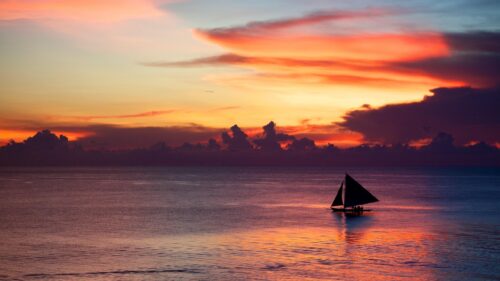 Serene Sailboat at Sunset over Calm Ocean Waters 4K Wallpaper