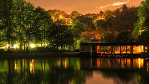 Serene Lakeside Park at Night with Golden Glow and Reflections Desktop Wallpaper