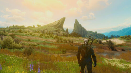 Geralt of Rivia Standing in a Scenic Witcher Landscape Desktop Wallpaper