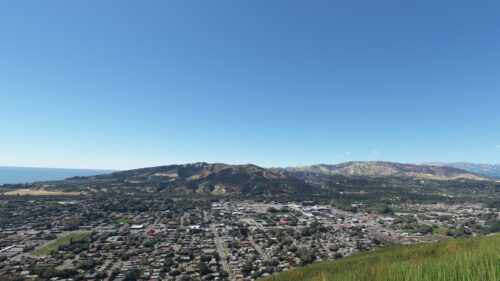 Panoramic Aerial View of Coastal Town nestled by Hills Desktop Wallpaper