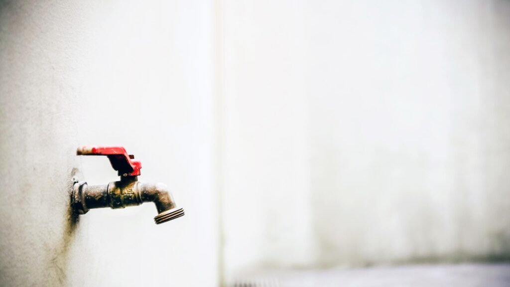 Minimalist Brass Outdoor Faucet with Red Handle Desktop Wallpaper