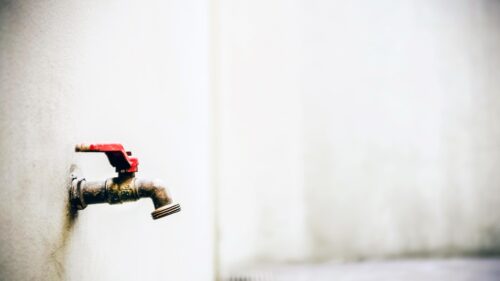 Minimalist Brass Outdoor Faucet with Red Handle Desktop Wallpaper