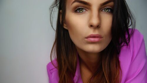 Stunning Portrait of a Woman with Green Eyes and Pink Shirt Desktop Wallpaper