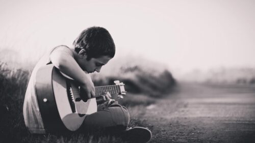 Young Boy Playing Acoustic Guitar Outdoors Black and White 4K Desktop Wallpaper