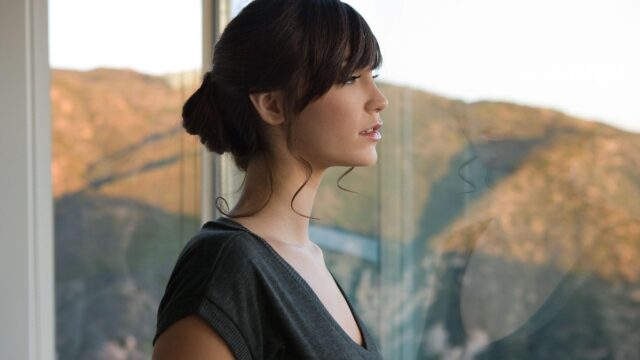 Elegant Woman Looking Out of a Window at Sunset Desktop Wallpaper
