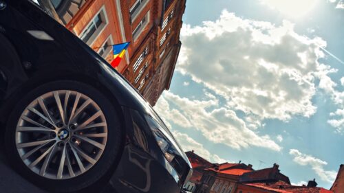 Low Angle Shot of a Luxury BMW Car Against Historic European Architecture 4K Wallpaper