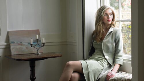 Elegant Young Woman Sitting by a Vintage Window Desktop Wallpaper