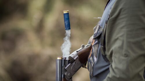 Close Up of Smoking Shotgun Shell Ejecting After Firing 4K Desktop Wallpaper