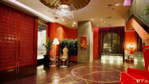 Luxurious Hotel Lobby Interior with Ornate Red Decor and Elegant Chandelier Desktop Wallpaper