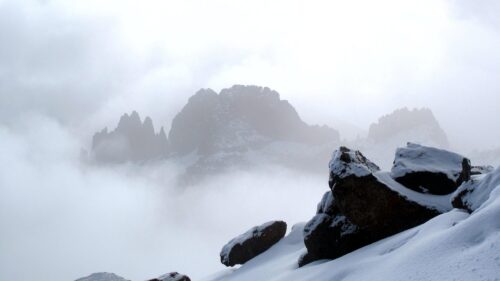Misty Mountain Peaks Amidst Snow and Clouds Desktop Wallpaper