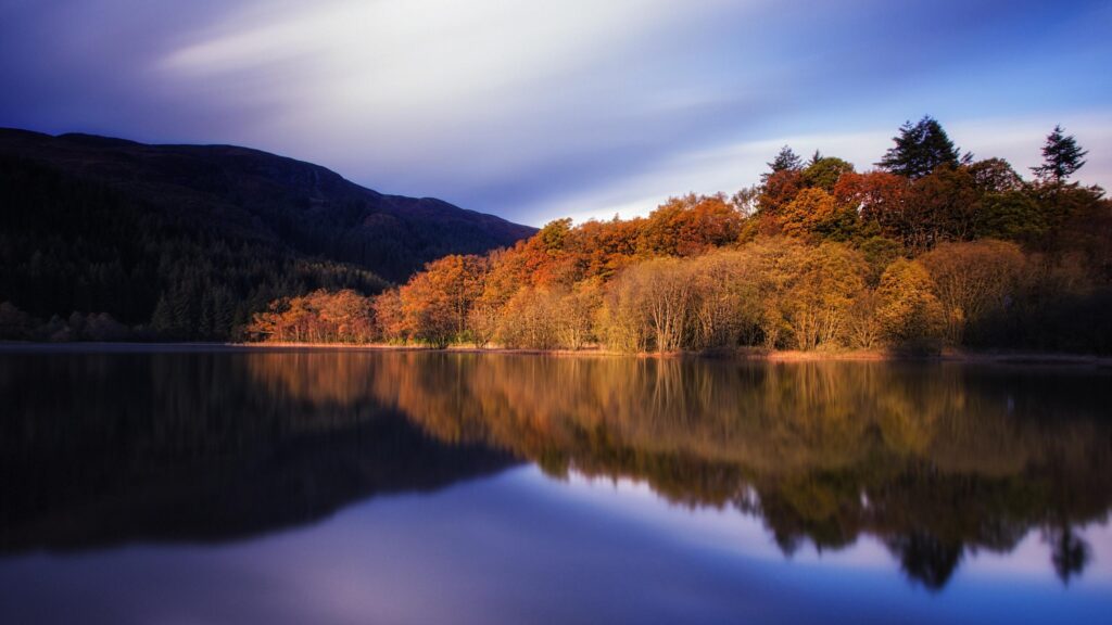 Stunning Autumn Reflection on a Calm Scottish Lake 4K Desktop Wallpaper