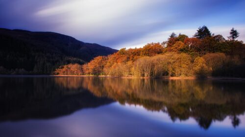 Stunning Autumn Reflection on a Calm Scottish Lake 4K Desktop Wallpaper